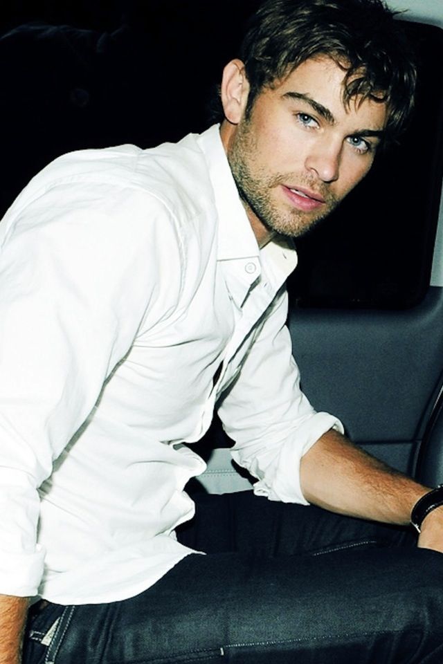 a man sitting in the back seat of a car wearing a white shirt and tie