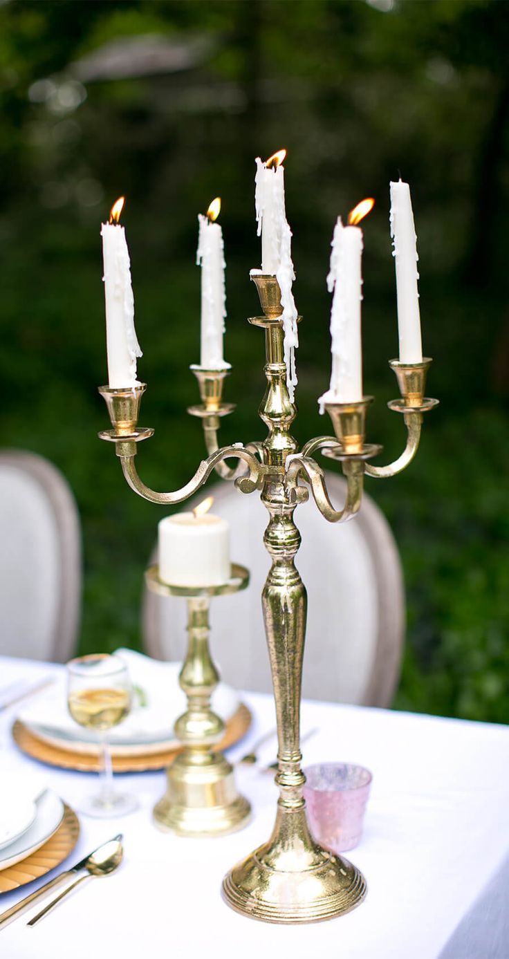 a candelabra that is sitting on top of a table with plates and silverware