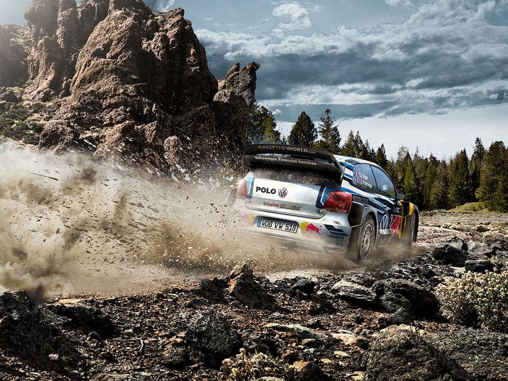 a rally car driving through the rocks on a dirt road