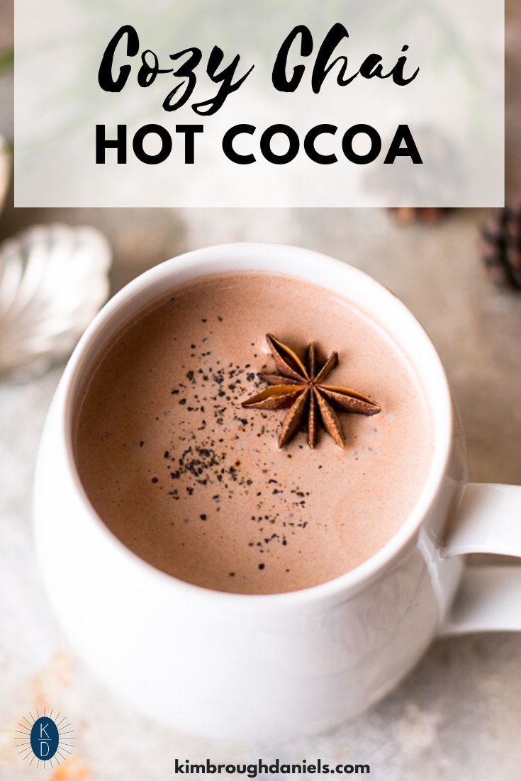 a cup of hot chocolate with anise on top and the words cozy chai hot cocoa