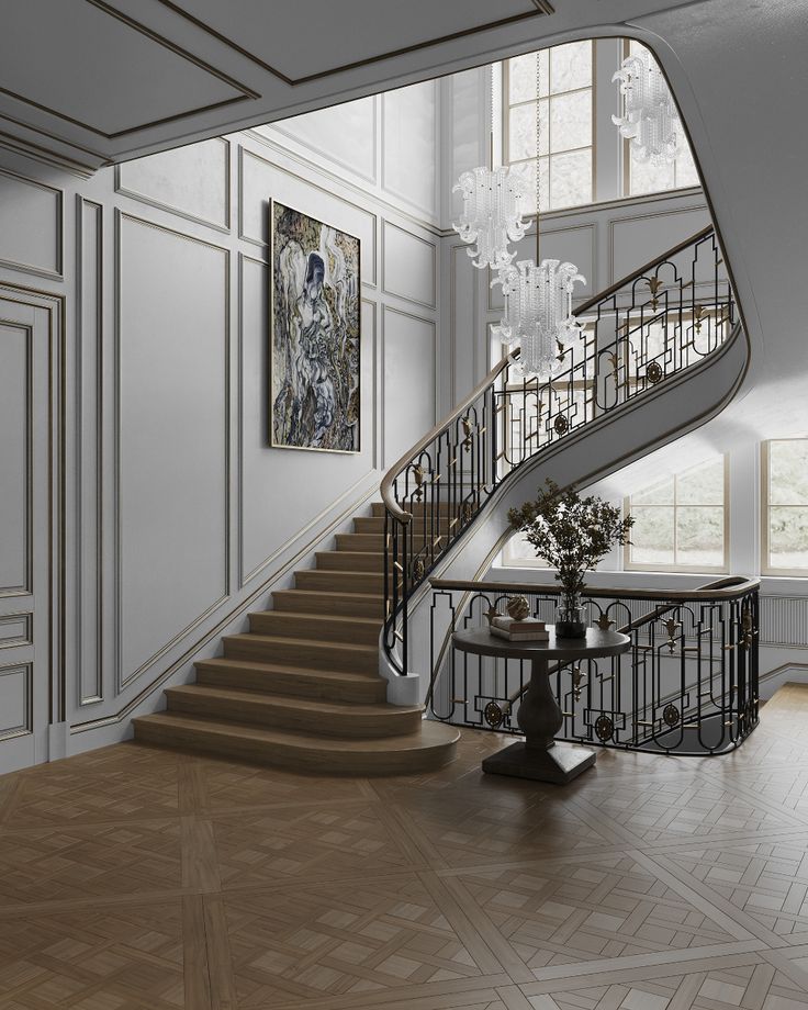 an elegant staircase with chandelier and paintings on the wall