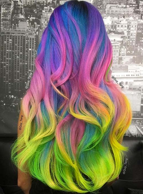 the back of a woman's head with multicolored hair in front of a cityscape