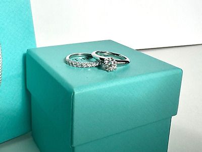 two wedding rings sitting on top of a blue box