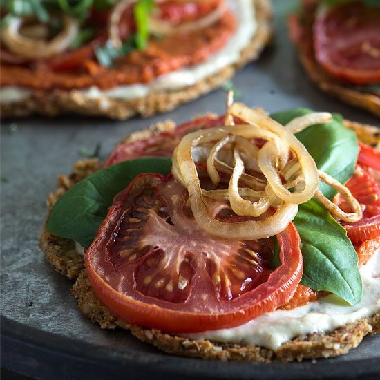 tomatoes, onion and cheese on crackers with basil sprinkled on the top