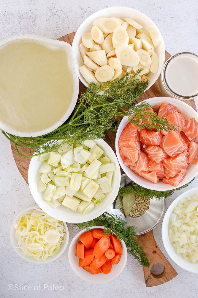 the ingredients for this dish are arranged on a cutting board, including carrots, celery, and fish