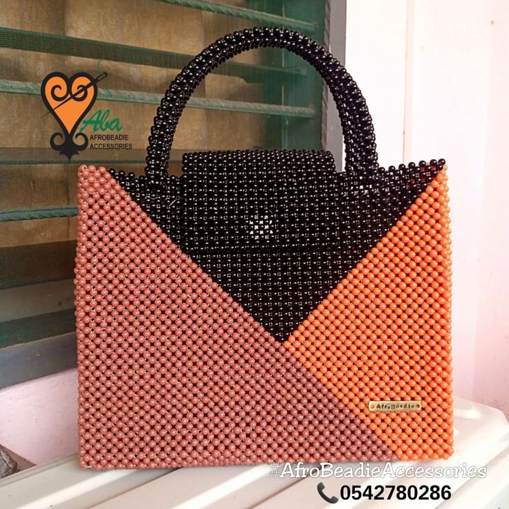 an orange and black purse sitting on top of a window sill