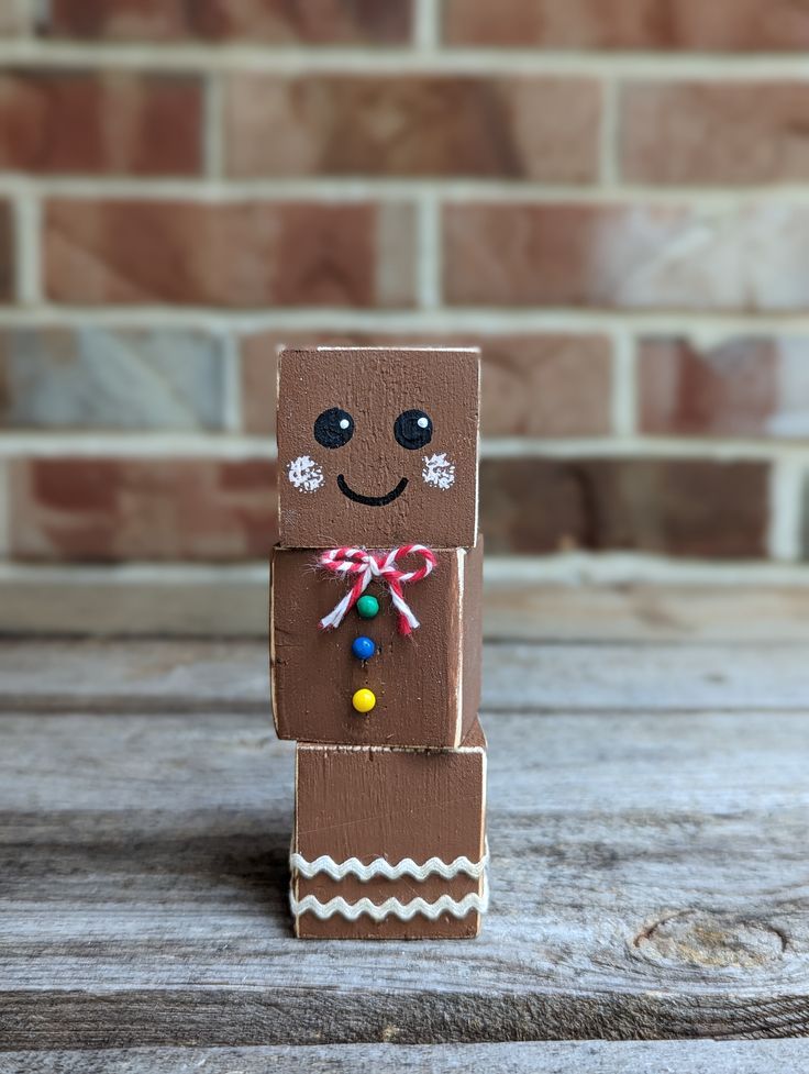 a wooden block with a smiling face on it's side and candy in its mouth