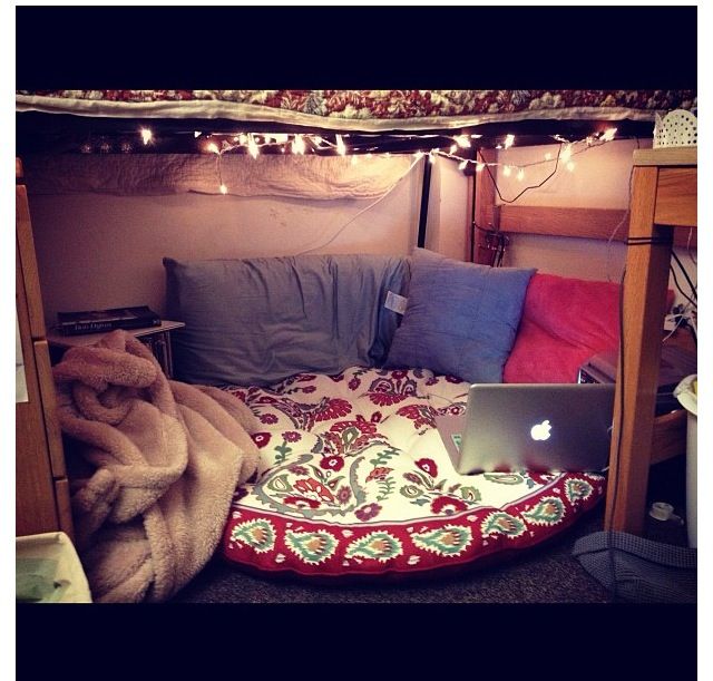 an open laptop computer sitting on top of a bed under a canopy covered in lights