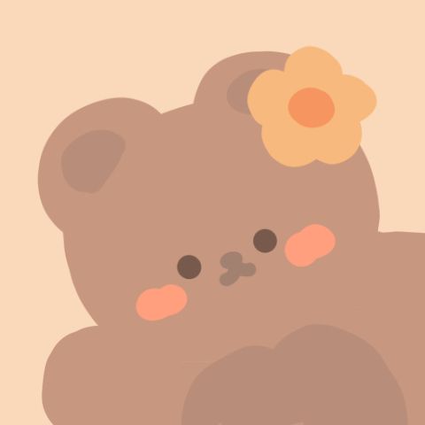 a brown teddy bear with a flower on its head sitting in front of a wall