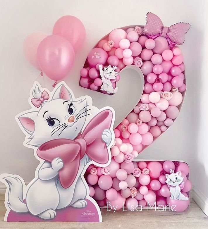 the number two is made out of balloons and has a cartoon cat on it with a bow around its neck