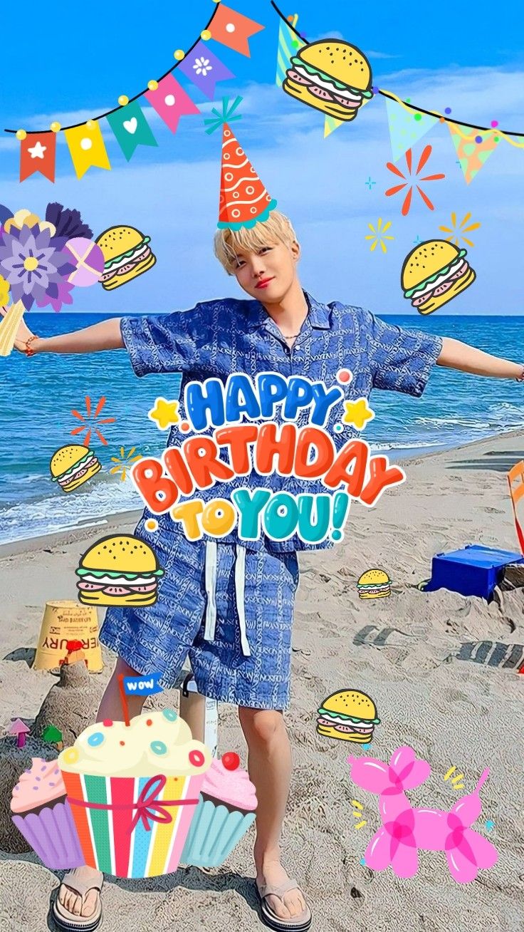 a boy standing on the beach with his arms out in front of him, holding a sign that says happy birthday to you