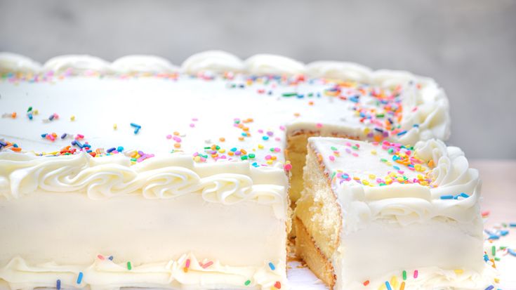 a cake with white frosting and sprinkles