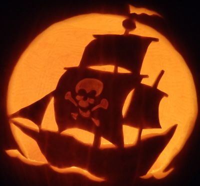 a carved pumpkin with a pirate ship on it