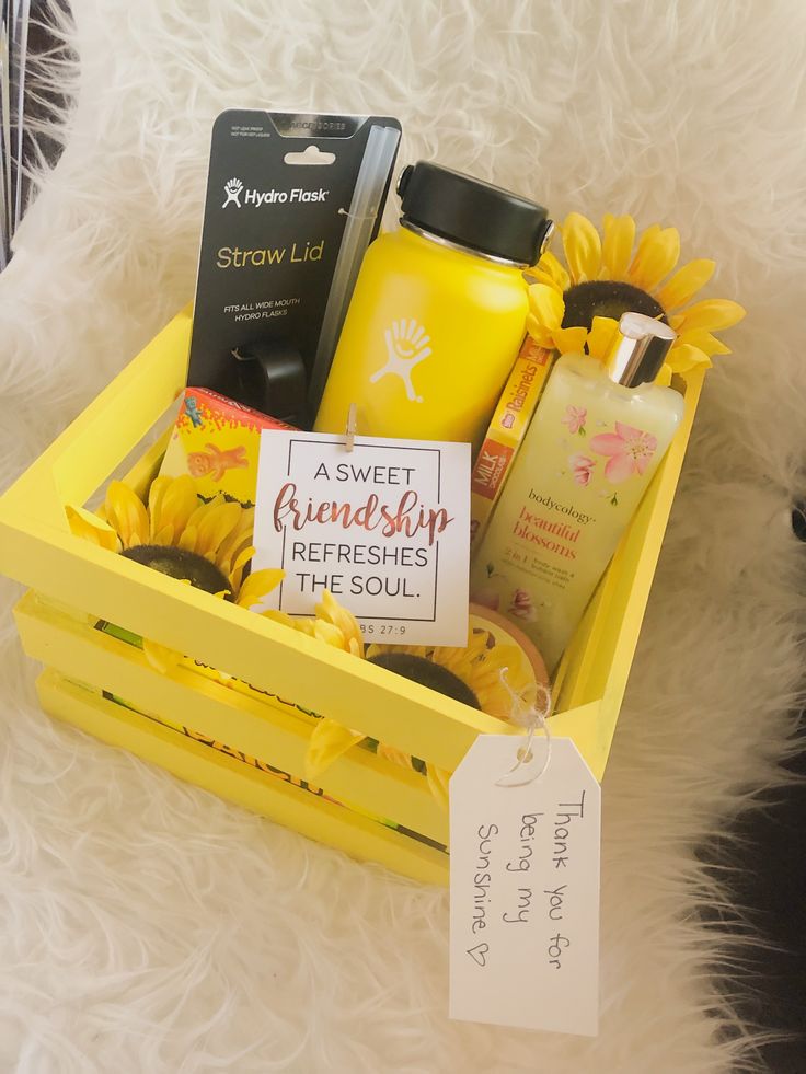 a yellow box with sunflowers and personal care items in it sitting on a white furnishing