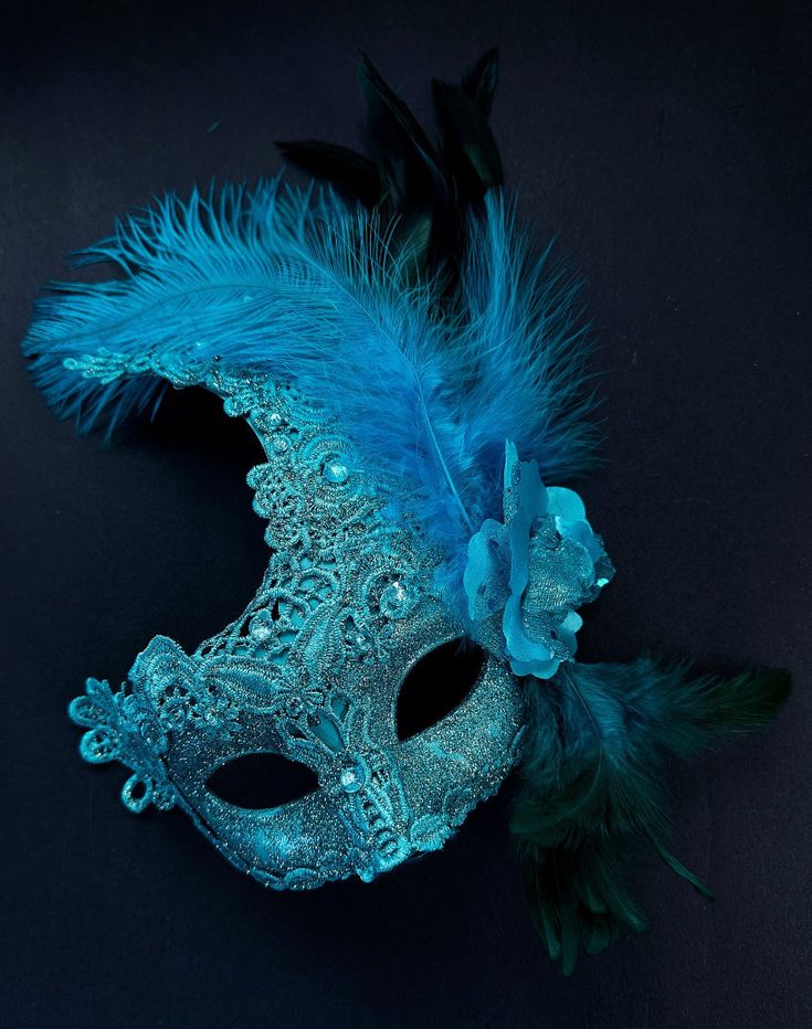 The brocade lace design with feathers adds a touch of sophistication and the jewels are carefully placed to catch the light and enhance your beauty. Securely and comfortably fits every face shape so you can enjoy a perfect evening at the masquerade ball.

Age Group/Gender - Adult/Women

Size/Type - One size fits all adults

Mask Color - Turquoise

Mask Material - Polyresin/Fabric

Accent Material - Gems Mardi Gras Mask Decorating Ideas, Elegant Blue Masquerade Mask For Parties, Elegant Feathered Masquerade Mask, Elegant Feathered Eye Mask For Masquerade, Elegant Feathered Masquerade Mask For Costume Party, Elegant Blue Eye Mask For Masquerade, Masquerade Mask Feathers, Blue Masquerade Mask, Masquerade Aesthetic