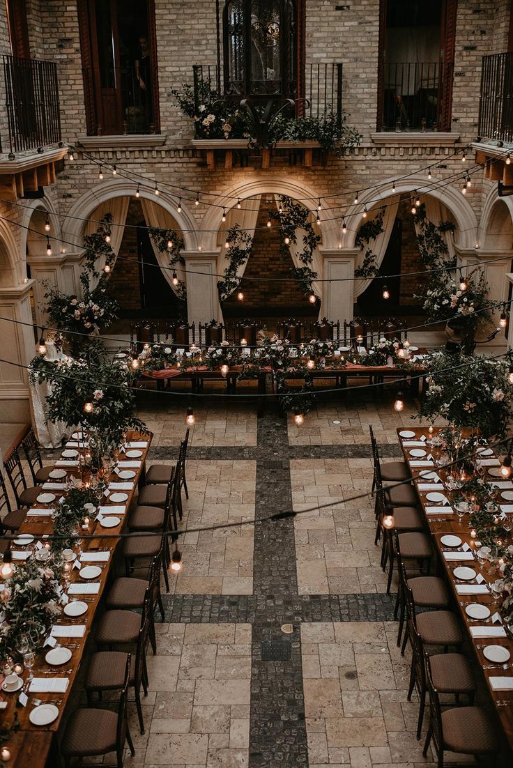 an indoor venue with tables and chairs set up for a formal dinner in the center