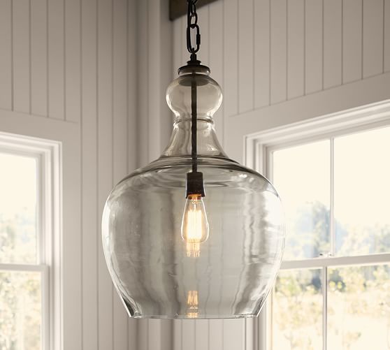 a light fixture hanging from a ceiling in a room with two windows and white walls