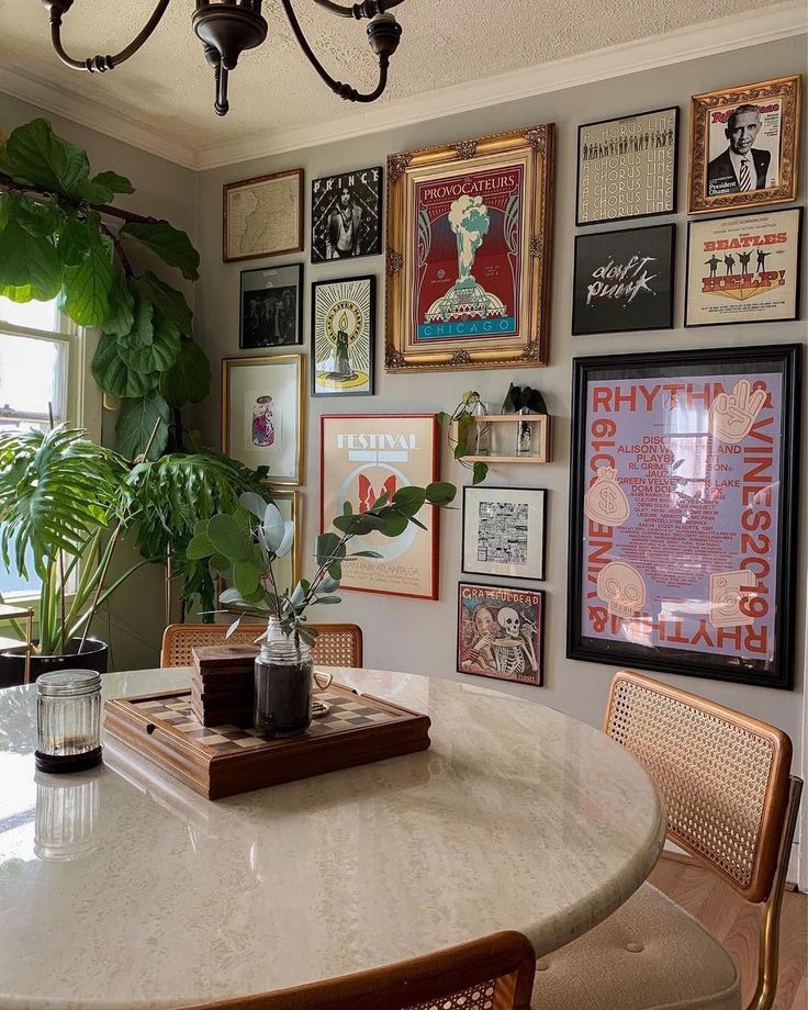 a dining room table surrounded by pictures and plants