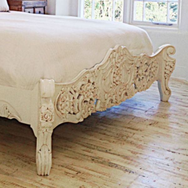 a white bed sitting on top of a hard wood floor