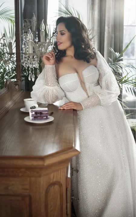 a woman in a white dress standing next to a table