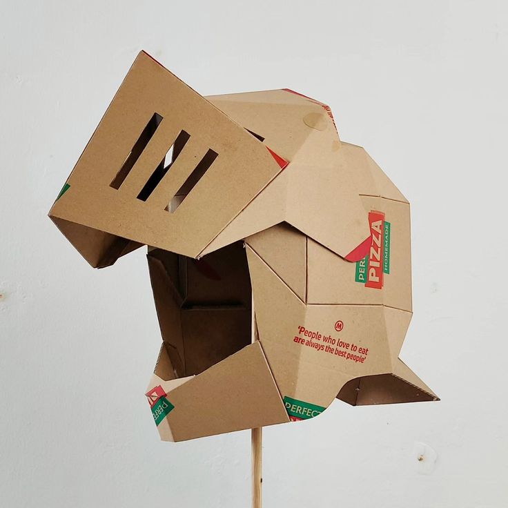 an animal made out of cardboard sitting on top of a stick