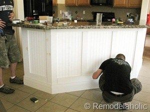 two men standing in a kitchen next to a counter