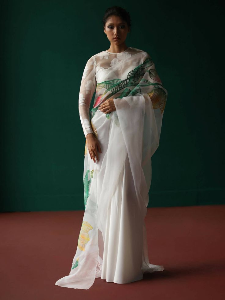 Saree with pre-stitched saree skirt adorned with tulip applique' on its pallu Set includes pre-stitched saree with and plain unstitched fabric for blouse. Shell fabric - novel organza & heavy novel satin ; Appliqué - printed crepe Colourful appliqué in our tulip pattern. *Closure: concealed zipper at centre back Components - 2 Please note: Stitched blouse is not included. White Fitted Pre-draped Saree For Eid, Semi-stitched Cotton Silk Pre-draped Saree With Floral Embroidery, Floor-length Pre-draped Saree With Floral Embroidery, Transitional Pre-draped Floral Saree, Transitional Season Pre-draped Floral Saree, White Organza Pre-draped Saree With Unstitched Blouse, Transitional White Saree With Sheer Dupatta, Fitted Pre-draped Cotton Silk Saree With Resham Embroidery, Eid Cotton Silk Pre-draped Saree