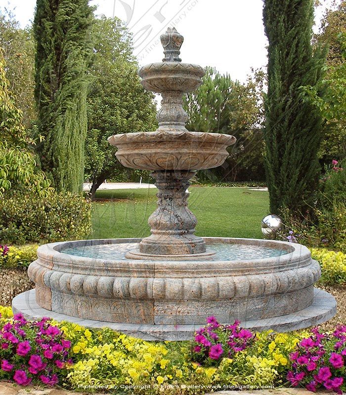 a water fountain surrounded by flowers and trees