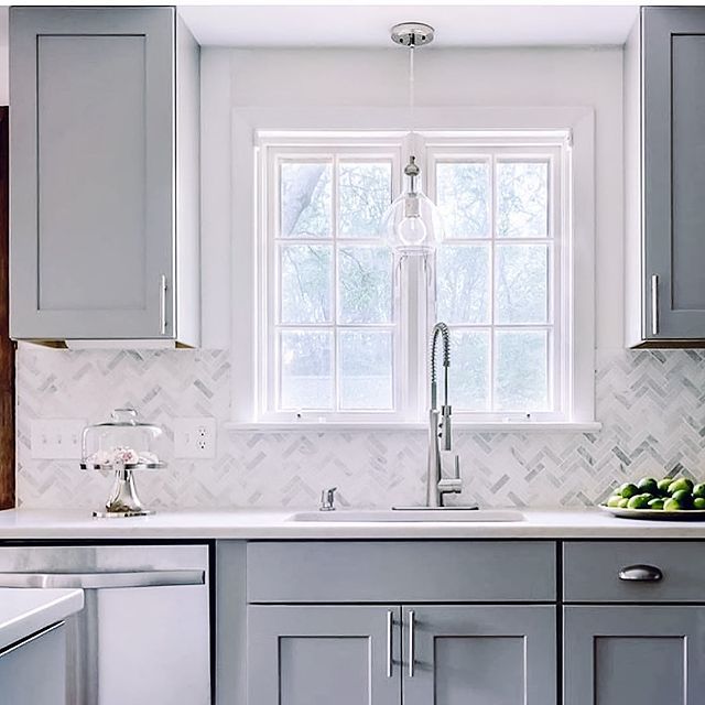 a kitchen with gray cabinets and white counter tops