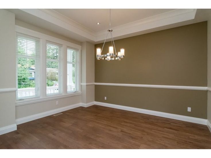 an empty room with hard wood floors and white trim on the walls, along with two windows