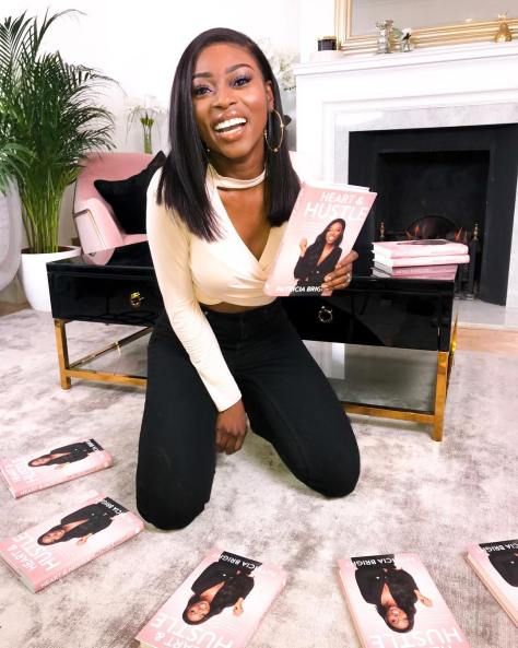 a woman is sitting on the floor with some books in front of her and smiling