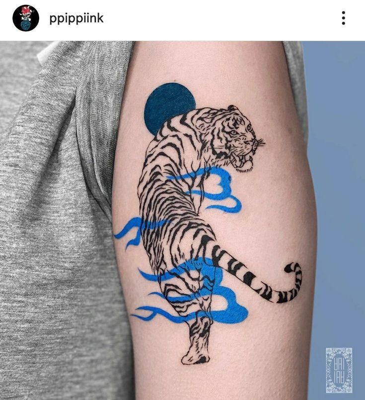 a man with a tiger tattoo on his arm, and the image is in blue ink