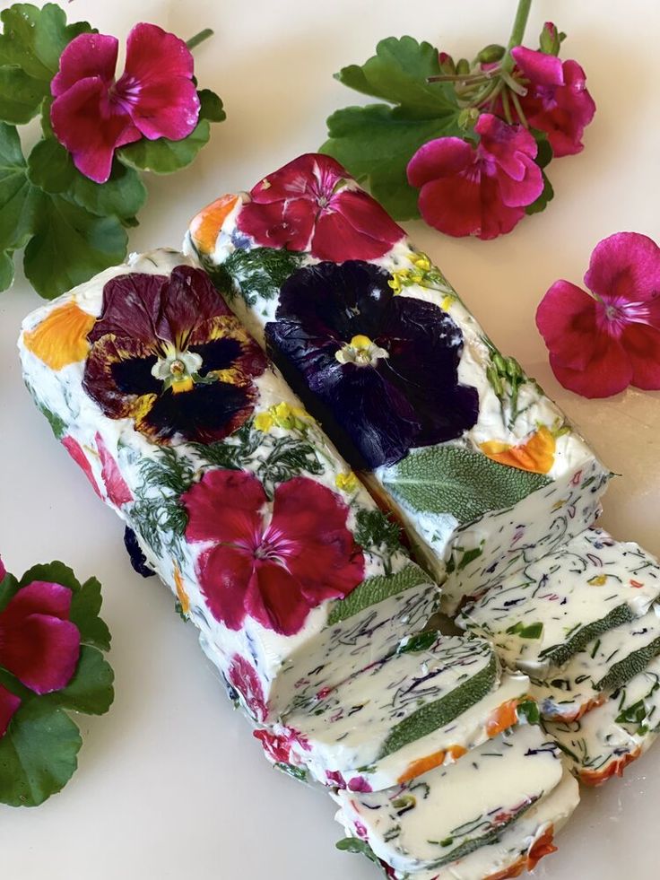 a piece of cake sitting on top of a white table next to red and purple flowers