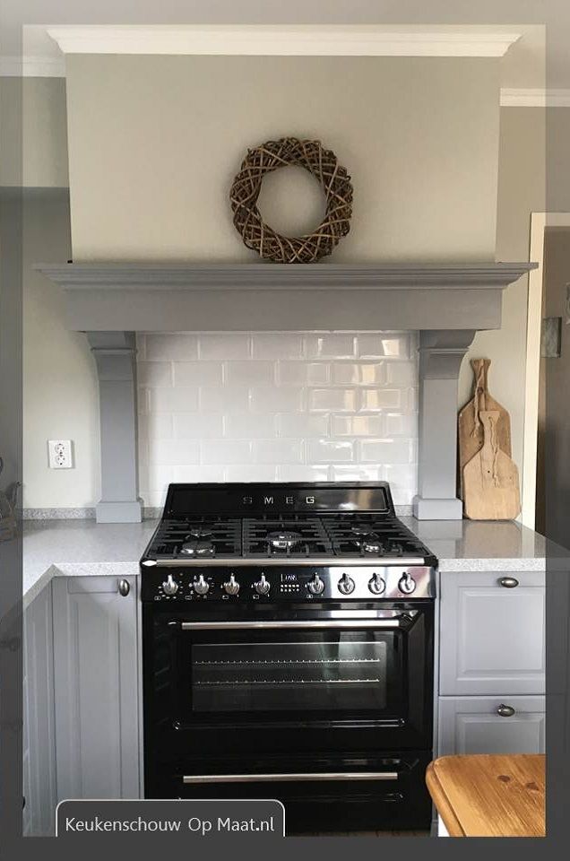 a black stove top oven sitting inside of a kitchen next to a counter and wooden cutting board