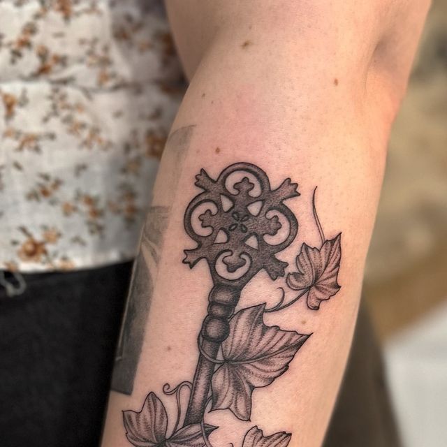 a person with a tattoo on their arm holding a key