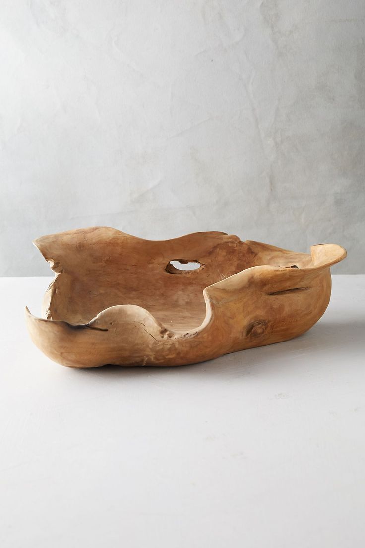 a wooden bowl sitting on top of a white table