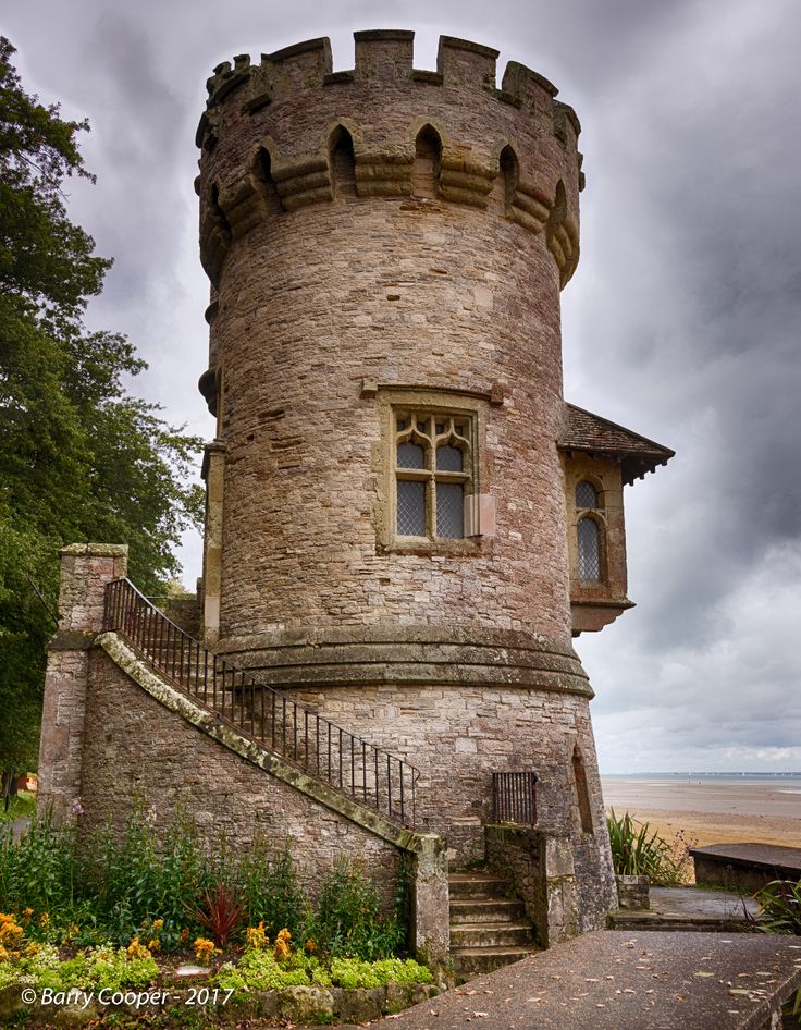 an old castle like building with stairs leading up to the door and windows on it