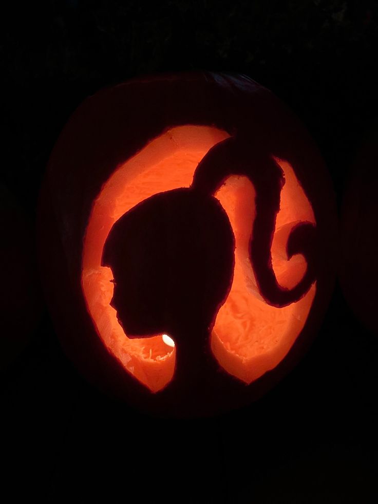 a carved pumpkin with a cat on it's face and the shape of a circle