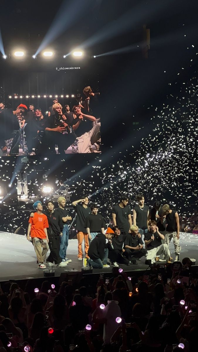 a group of people standing on top of a stage with confetti in the air