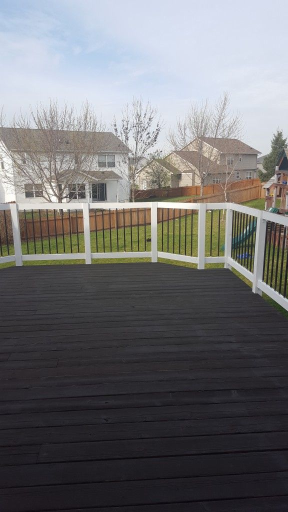 a deck with black and white railings next to houses