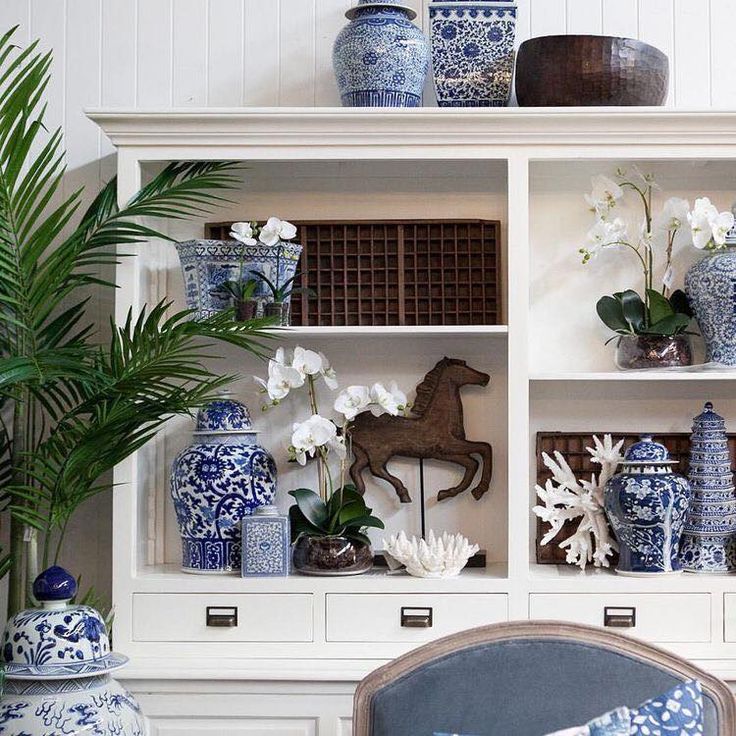 blue and white vases are sitting on shelves in a room with other decorative items