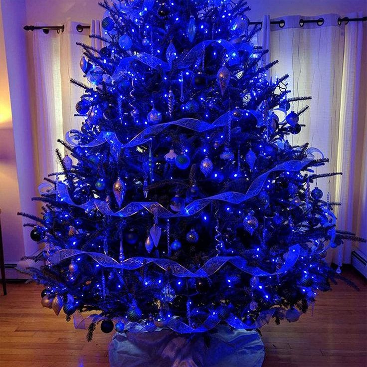 a blue lighted christmas tree in a living room