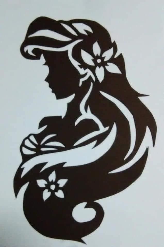 the silhouette of a woman with long hair and flowers in her hair is drawn on a sheet of paper