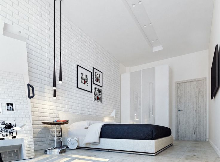 a bedroom with white brick walls and flooring is furnished with black and white furniture