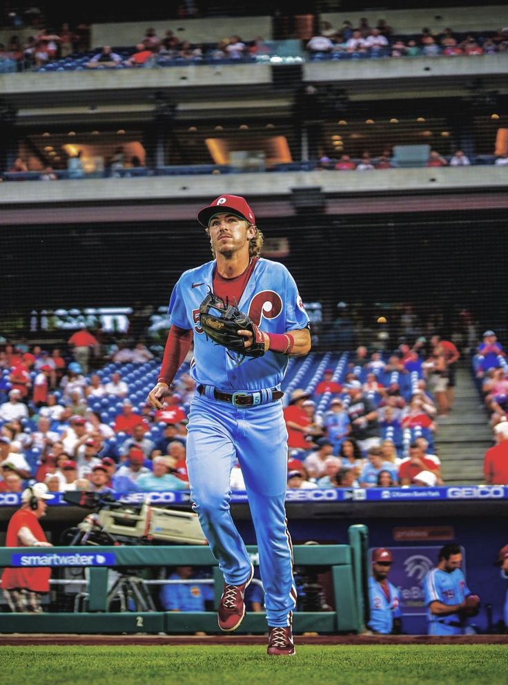 a baseball player is running on the field in front of an empty stadium full of people