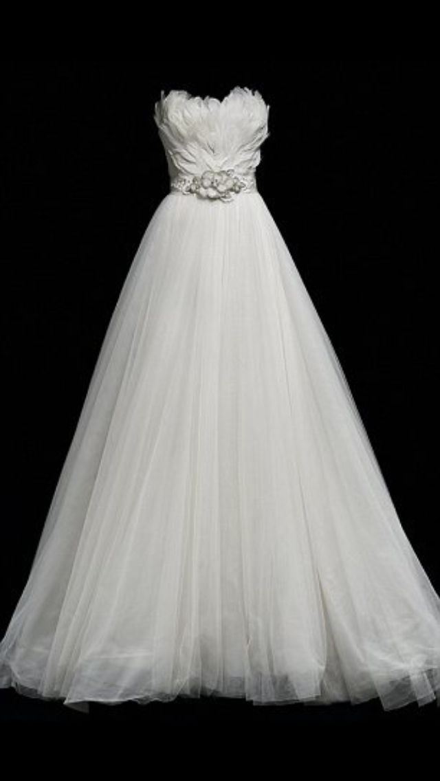 a white wedding dress with flowers on the waist and skirt, in front of a black background