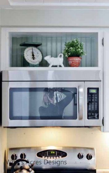 a white microwave oven sitting on top of a counter next to a potted plant