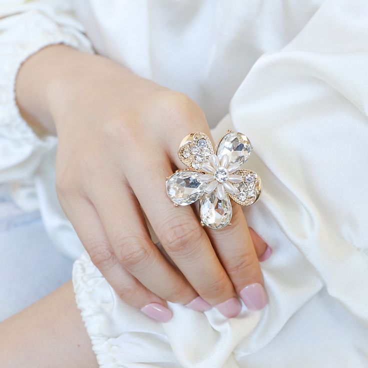 Give your hands a little dazzle with this Leah Daisy Rhinestone ring that'll make your outfit instantly pop! This Leah rhinestone cluster ring is crafted in a "flower petal" design to create an elegant and sophisticated look. Add this cocktail statement jewelry towards your fashion accessories collection. Size• Length: 1.5 in (3.81 cm) • Height: 1.2 in (3.05 cm) QualityCrafted with eco-friendly, lightweight, strong gold color metal alloy. Firmly attaching shiny large beautiful top quality red cr Make Your Outfit, Stretch Ring, Pearl Shop, Rhinestone Ring, Flower Petal, Pearl Set, Accessories Collection, Red Crystals, Matching Bracelets