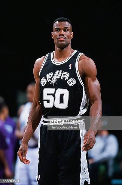 a basketball player standing on the court with his hands in his pockets and looking at the camera