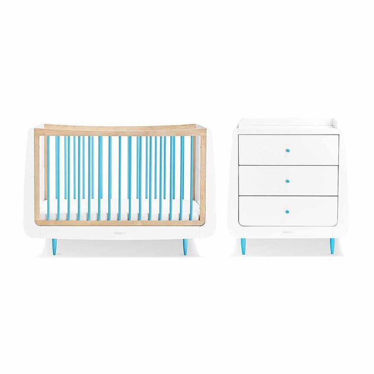 a baby crib next to a white dresser